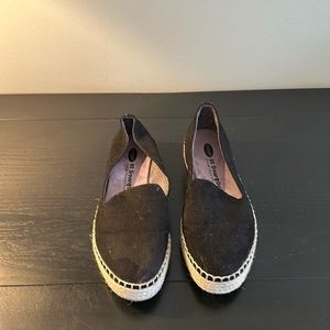 Black espadrille flats with straw soles.